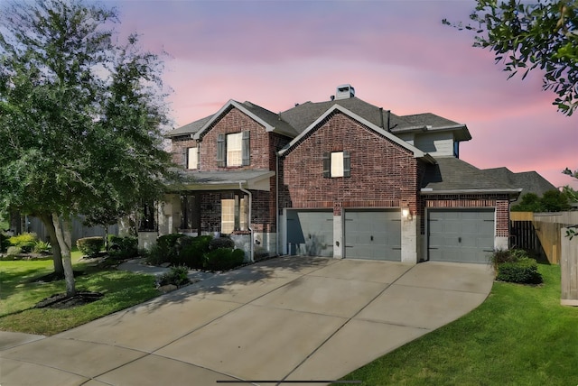 view of front of property featuring a garage and a lawn