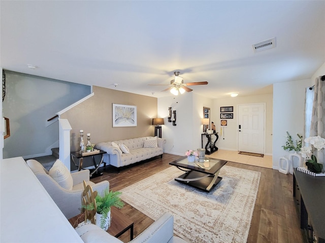 living room with ceiling fan and dark wood-type flooring