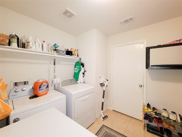 laundry area featuring washer and dryer and light tile patterned floors