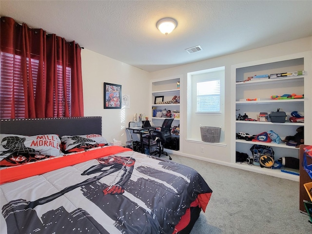 bedroom with carpet floors and a textured ceiling