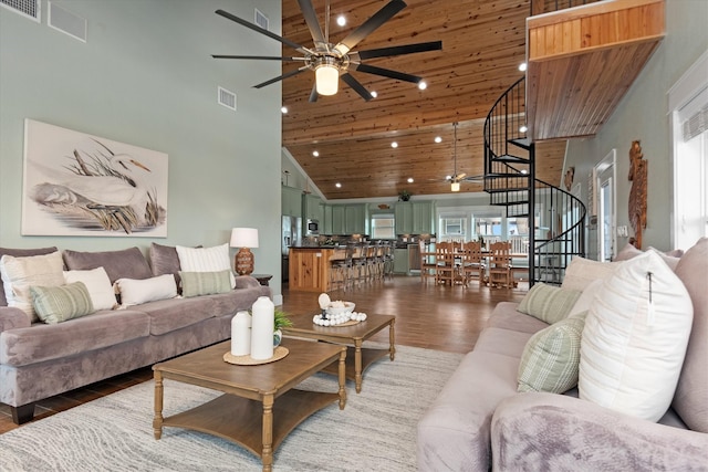 living room featuring a towering ceiling, dark wood-type flooring, and wooden ceiling