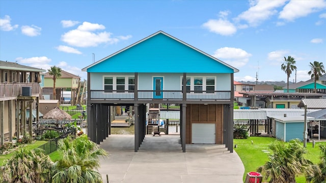 rear view of property featuring a balcony and a lawn