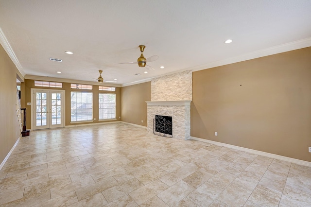 unfurnished living room with ceiling fan, a stone fireplace, crown molding, and french doors