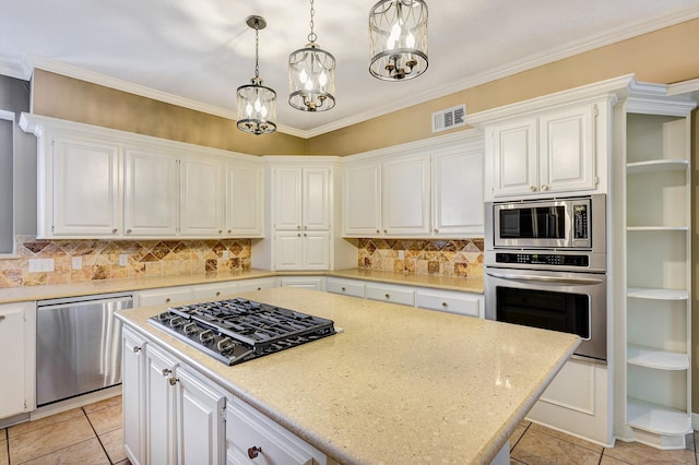 kitchen featuring white cabinets, a center island, stainless steel appliances, and hanging light fixtures