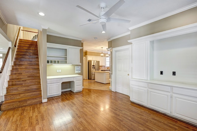 kitchen with white cabinetry, stainless steel fridge, ceiling fan, and decorative light fixtures