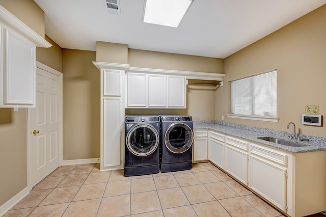 washroom featuring light tile patterned flooring, cabinets, sink, and washing machine and dryer