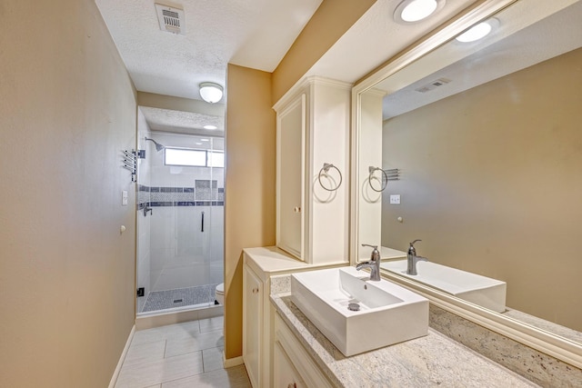 bathroom with vanity, tile patterned floors, toilet, a textured ceiling, and an enclosed shower