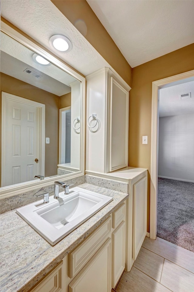 bathroom featuring tile patterned floors, vanity, and a textured ceiling