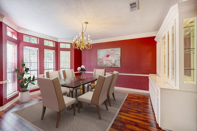 dining space featuring crown molding, dark wood-type flooring, and an inviting chandelier