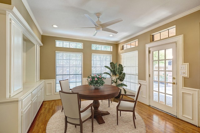 dining area with a wealth of natural light, light hardwood / wood-style floors, and ornamental molding