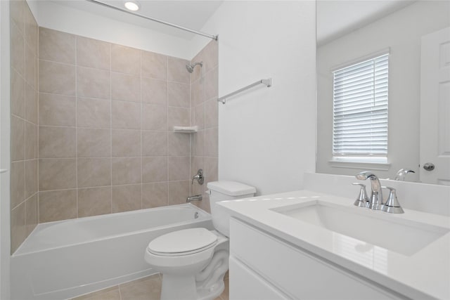 full bathroom with tile patterned flooring, vanity, tiled shower / bath combo, and toilet