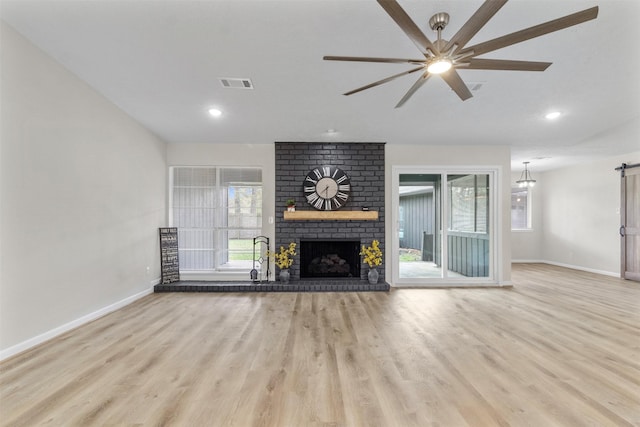 unfurnished living room with ceiling fan, light hardwood / wood-style floors, and a brick fireplace