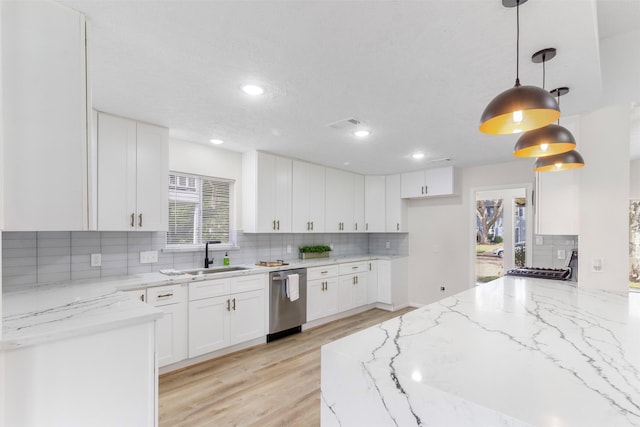 kitchen featuring sink, light stone counters, stainless steel dishwasher, decorative light fixtures, and white cabinets