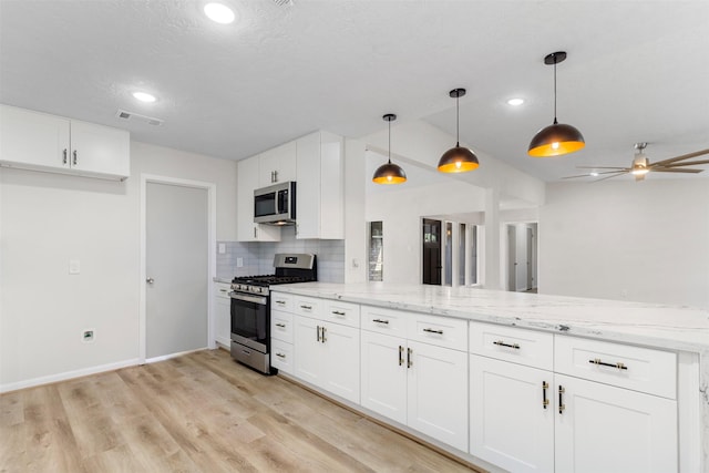 kitchen with white cabinets, decorative light fixtures, stainless steel appliances, and light stone counters