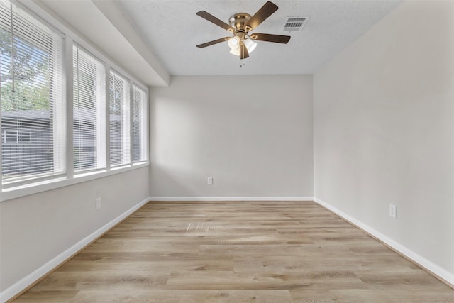 empty room featuring ceiling fan, light hardwood / wood-style floors, and a textured ceiling