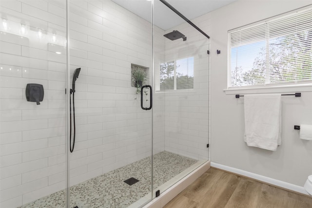 bathroom with hardwood / wood-style flooring and walk in shower