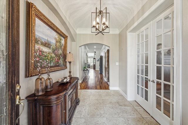 interior space featuring a chandelier, ornamental molding, and french doors