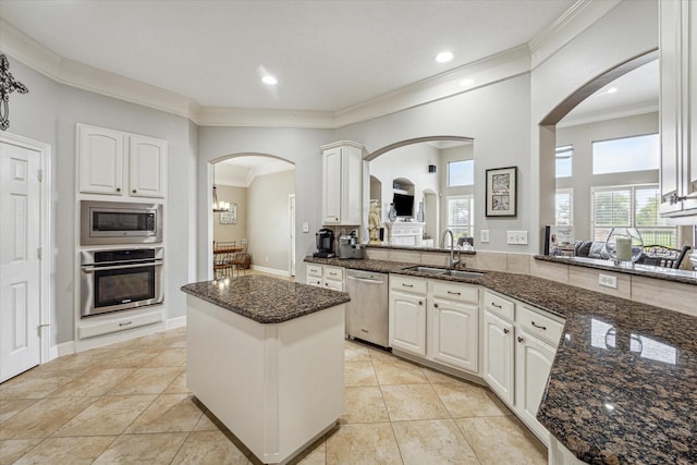 kitchen with dark stone counters, white cabinets, sink, kitchen peninsula, and stainless steel appliances