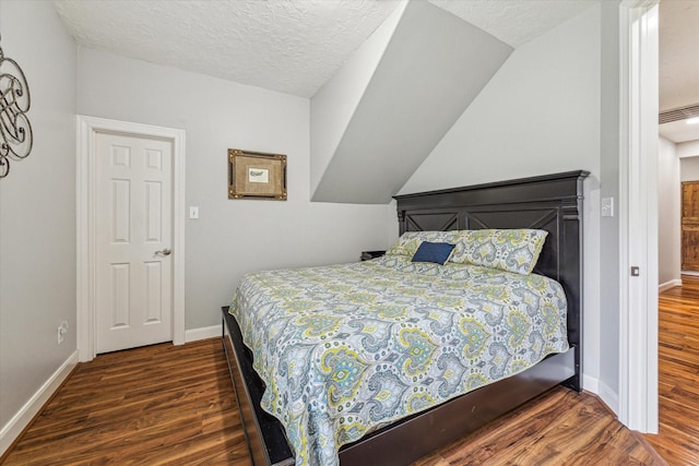 bedroom with a textured ceiling and dark hardwood / wood-style floors