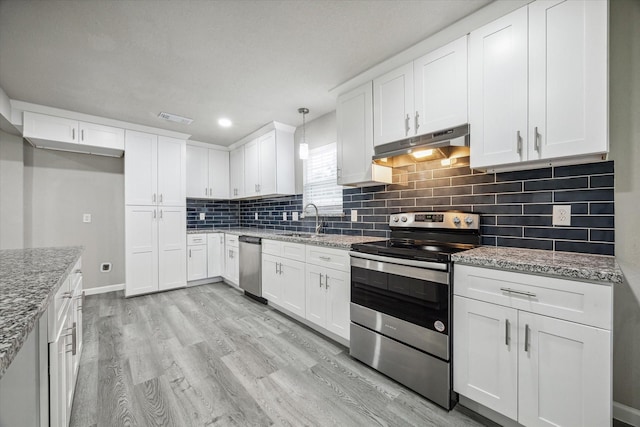 kitchen with white cabinets, appliances with stainless steel finishes, and hanging light fixtures