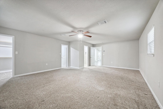 empty room with carpet flooring, a textured ceiling, and ceiling fan