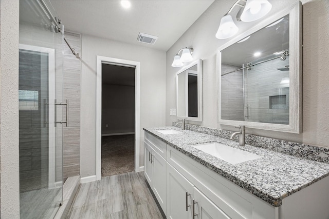 bathroom with vanity, hardwood / wood-style flooring, and walk in shower