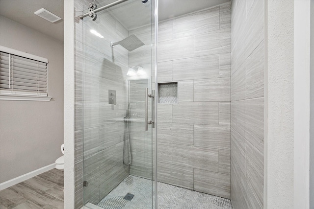 bathroom with an enclosed shower, toilet, and hardwood / wood-style flooring