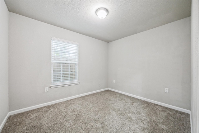 carpeted spare room featuring a textured ceiling