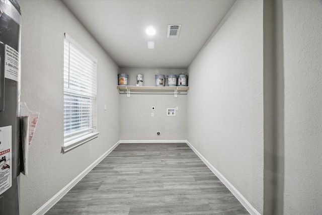 clothes washing area with hardwood / wood-style floors, plenty of natural light, hookup for an electric dryer, and hookup for a washing machine