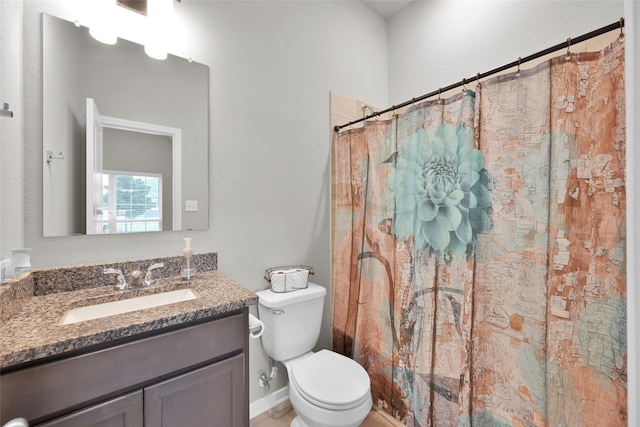 bathroom featuring a shower with curtain, vanity, and toilet