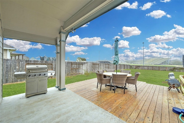 wooden terrace with a grill and a yard