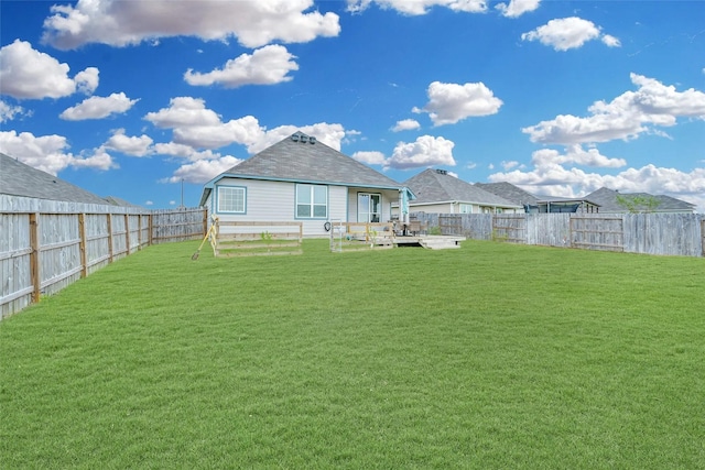 rear view of house with a wooden deck and a lawn