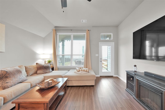 living room with hardwood / wood-style floors, ceiling fan, and lofted ceiling