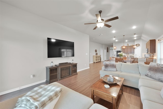 living room with hardwood / wood-style floors and ceiling fan