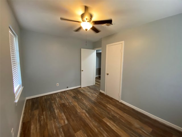 empty room featuring ceiling fan and dark wood-type flooring