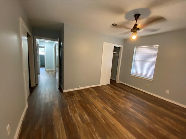 unfurnished bedroom featuring ceiling fan, dark hardwood / wood-style flooring, and a closet