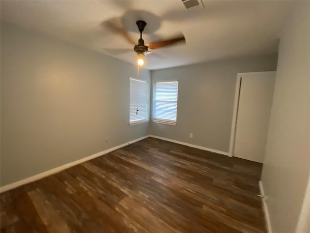 spare room with dark hardwood / wood-style flooring and ceiling fan