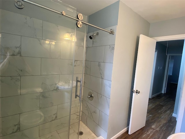 bathroom featuring a shower with door and hardwood / wood-style floors