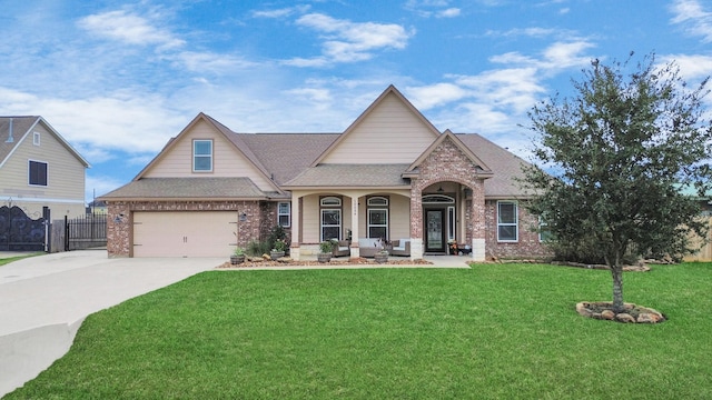 view of front of property featuring covered porch, a garage, and a front lawn