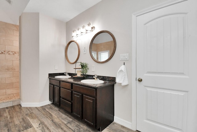 bathroom with walk in shower, vanity, and hardwood / wood-style flooring