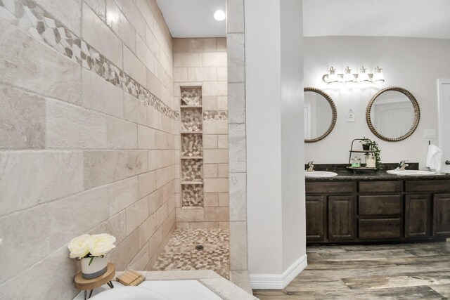 bathroom featuring hardwood / wood-style flooring, vanity, and a tile shower