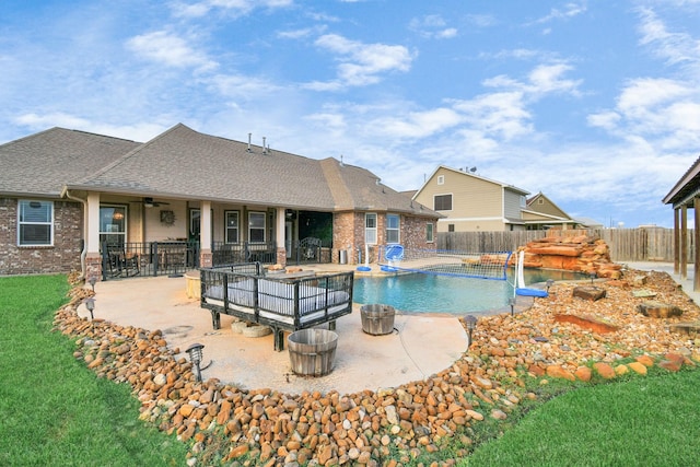 view of swimming pool with pool water feature, ceiling fan, and a patio area