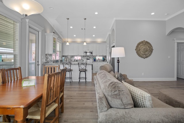 dining area with dark hardwood / wood-style floors, crown molding, and sink