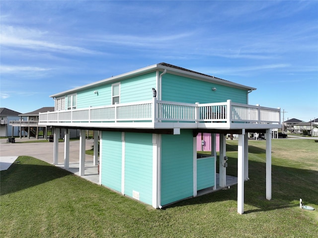 rear view of property featuring a patio, a lawn, and a wooden deck