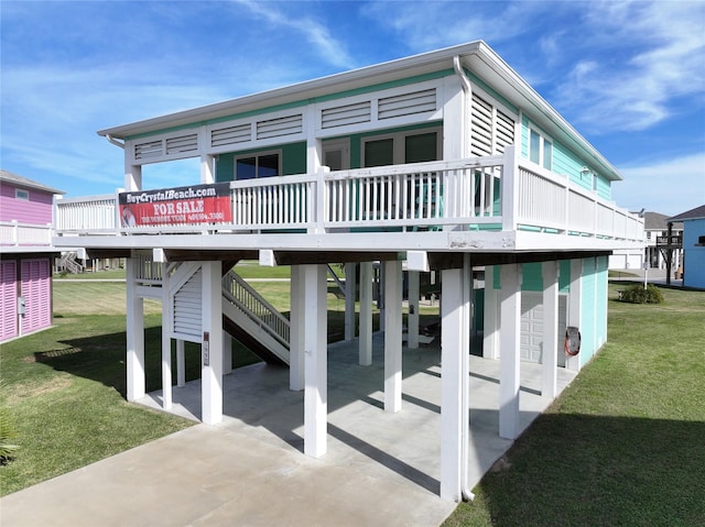 back of property featuring a wooden deck, a patio area, and a yard