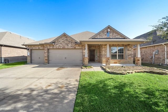 view of front of property with covered porch, a garage, and a front yard