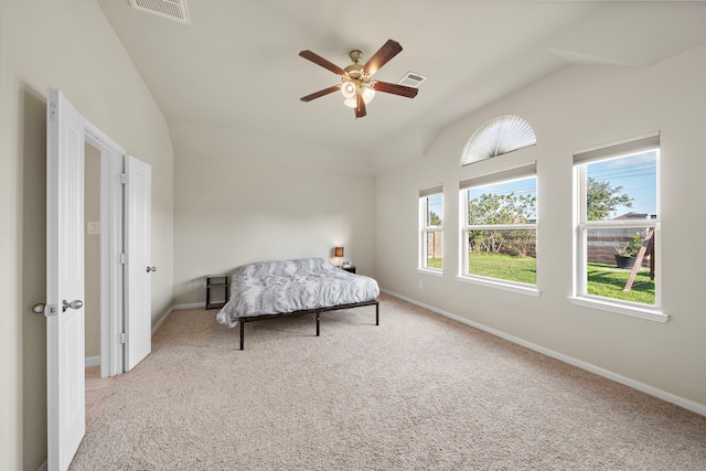 bedroom with ceiling fan, light colored carpet, and vaulted ceiling