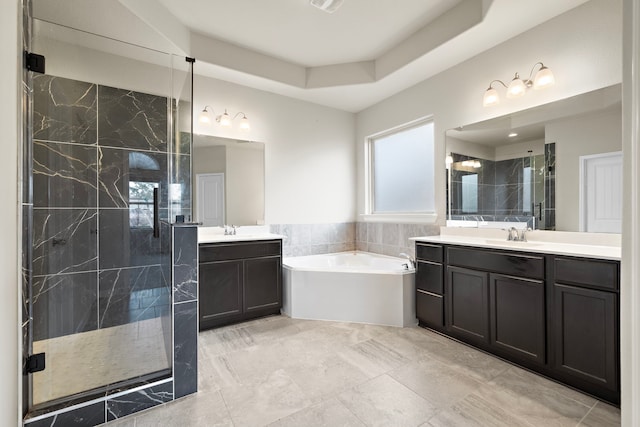 bathroom with vanity and shower with separate bathtub