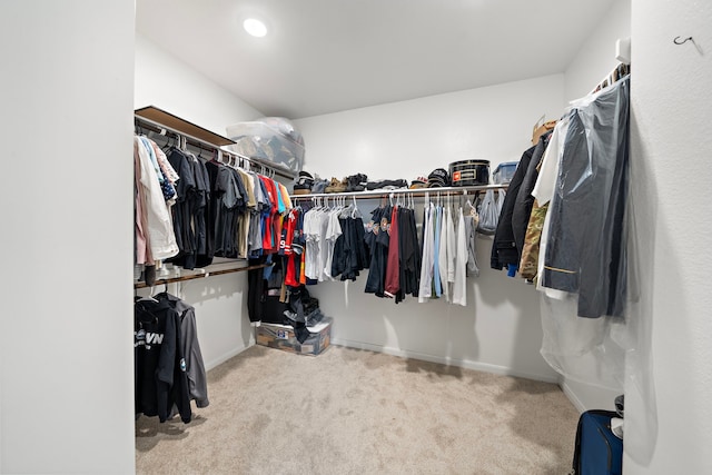 walk in closet with light carpet