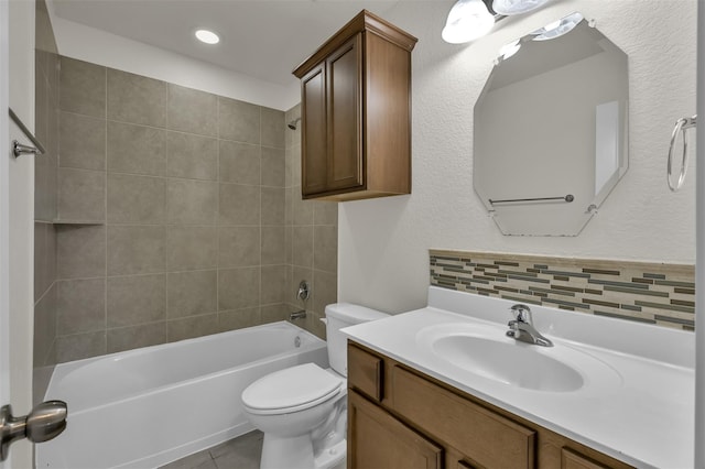 full bathroom featuring vanity, tile patterned floors, tiled shower / bath, toilet, and tasteful backsplash